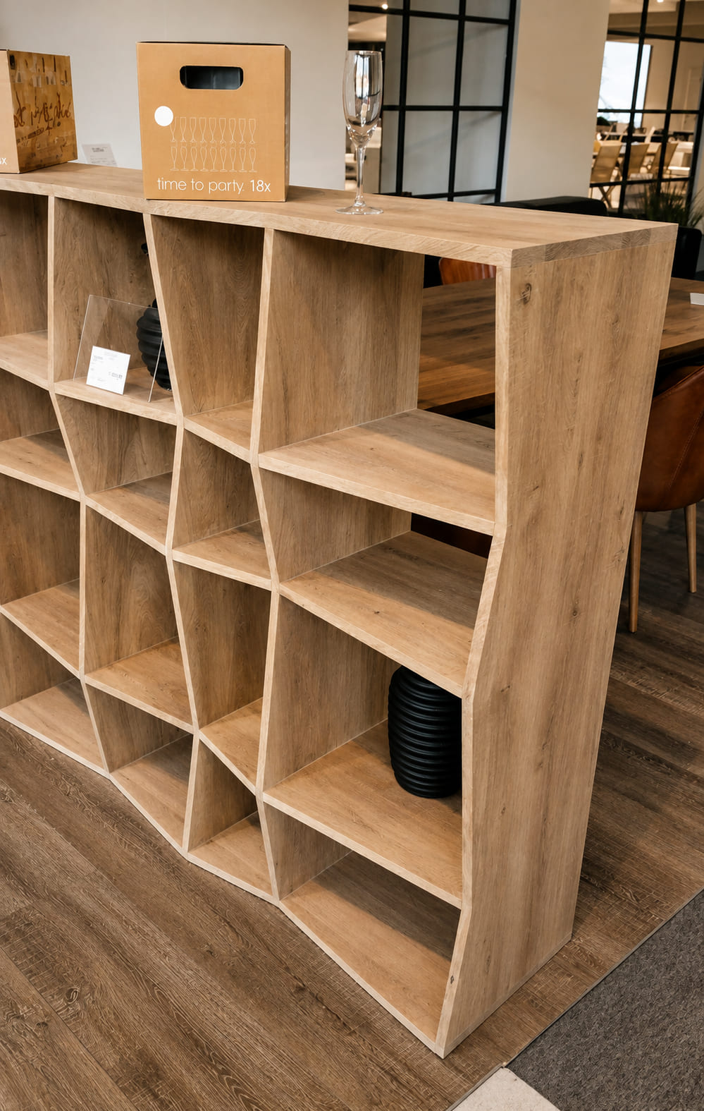 Raft de sine stătător din stejar cu compartimente înclinate în formă de romb într-un showroom