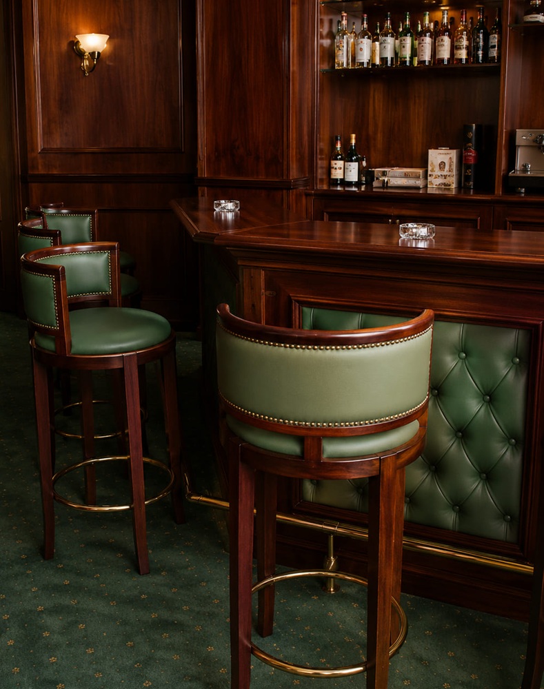 Bar din mahon cu front din piele verde capitonată și scaune de bar pivotante asortate